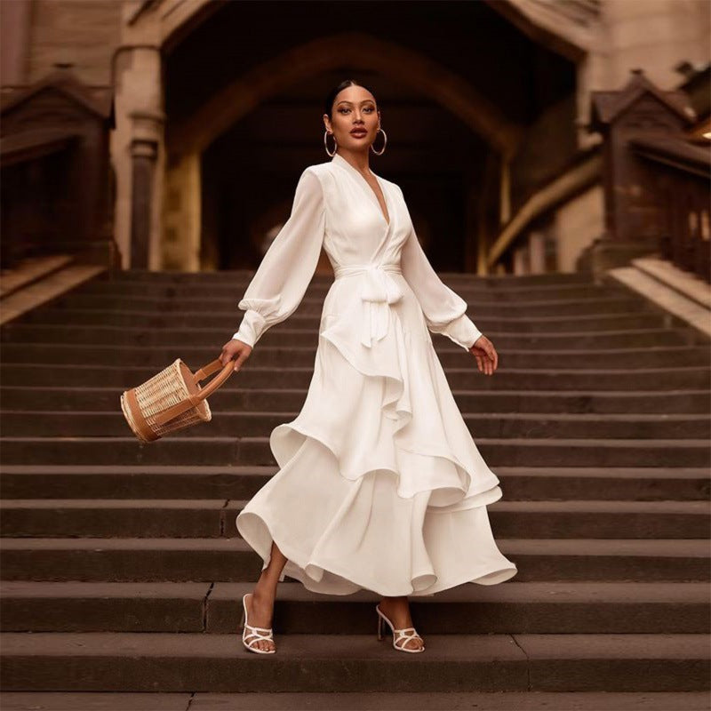 Woman in a white dress standing on stone steps with a rustic background