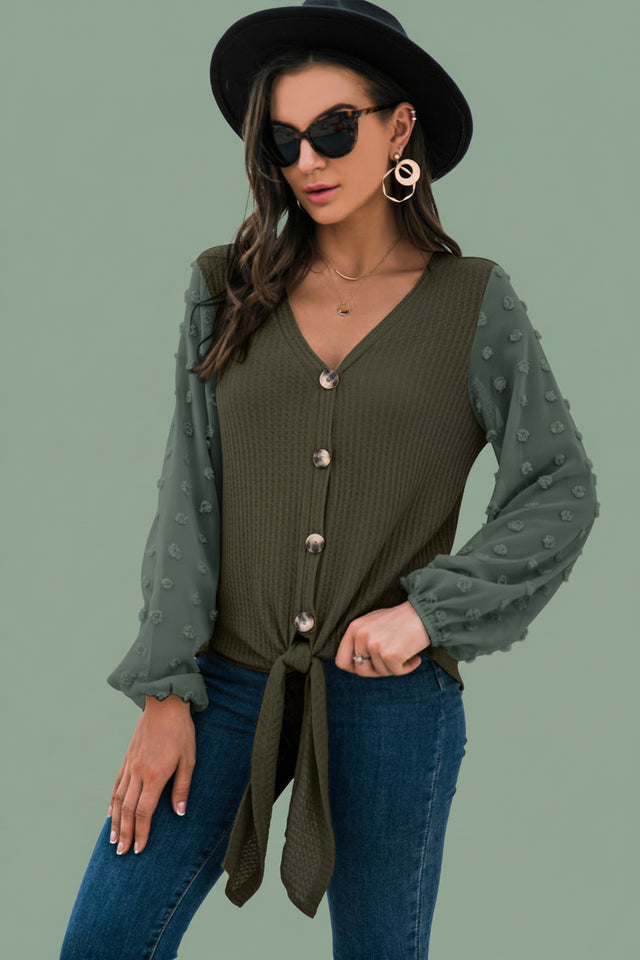 Close-up shot of soft apricot button-down cardigan sweater texture