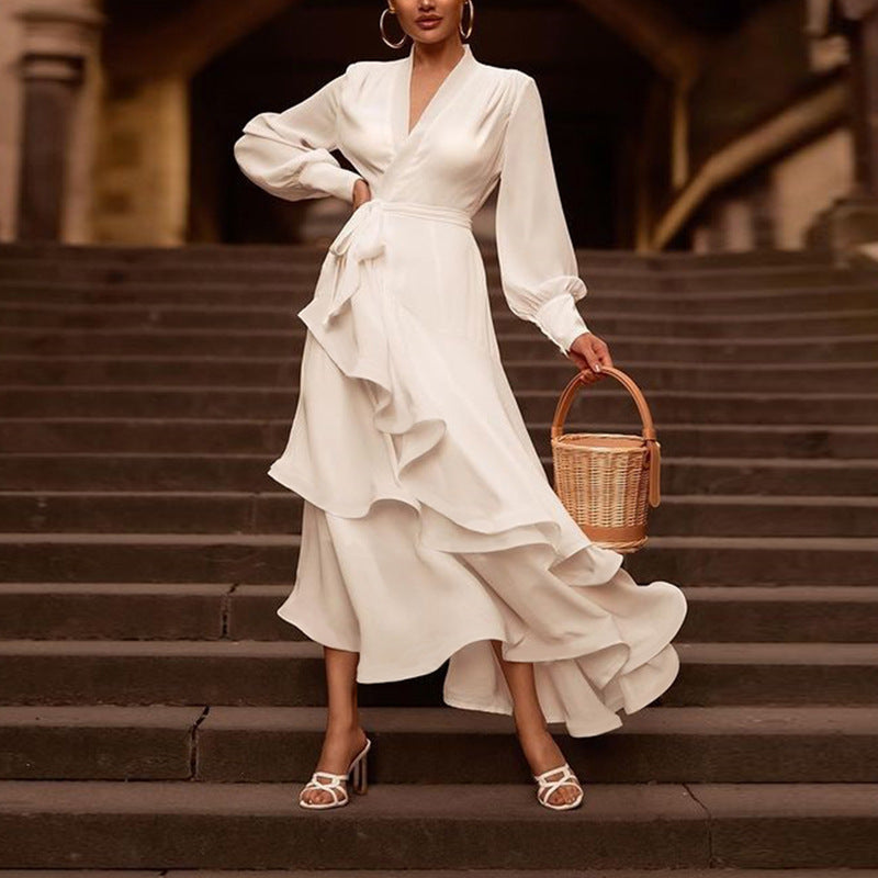 Woman in a white dress holding a woven basket on stone steps.