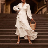Woman in a white dress holding a woven basket on stone steps.