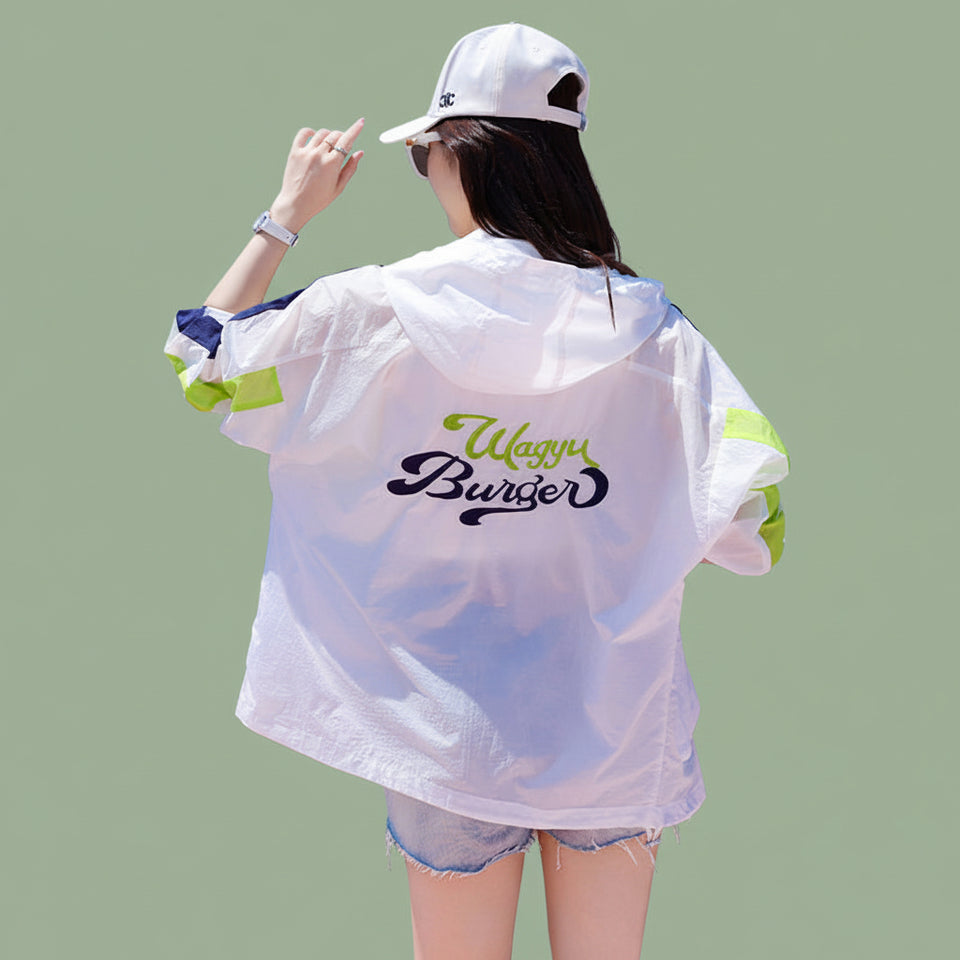 Side profile of a light pink UPF 50 summer jacket for women on a sunny beach walk